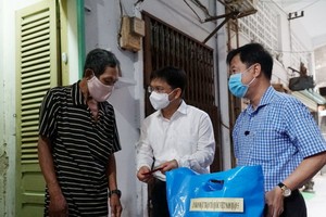 第五郡郡委書記阮孟強(右二)，郡越南祖國陣線委員會主席黎晉才(右一)探望貧困戶。