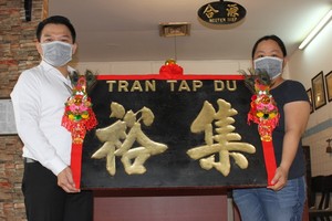 趣兒記者（右）把木雕老招牌捐贈給陳列室。