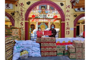 龍華寺住持釋慧功向郡祖國陣線委員會副主席范氏明月轉交救濟物資。