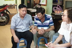 第五郡越南祖國陣線委員會主席黎晉才探訪華人榮軍張年就（中）。