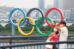 民眾與豎立在東京台場區域的奧運五環標誌合影。（圖源：新華社）