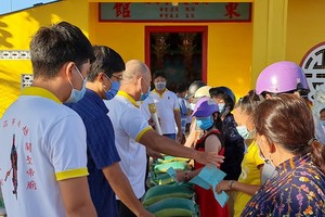 芽莊市廣東會館理事們向貧困者派發濟品。