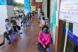 第三郡居民在Co.op Mart超市門外走廊排隊等候購物。（圖源：VnE）