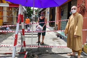 慈福精舍代表釋通振法師向第十坊隔離區貧困居民贈送必需品。