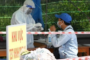 茶榮省防疫工作人員在一個檢疫點為一名過站男性進行快捷核酸檢測。（圖源：胡江）