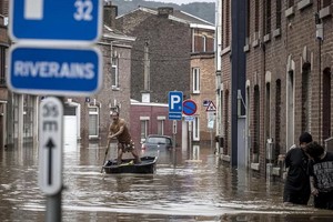 7月16日，在比利時列日，一名男子在洪水過後劃船沿著住宅街道行駛。（圖源：AP）