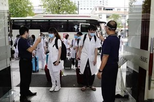 本市一家酒店人員站在大門口迎接前來支援本市抗疫的一線醫護人員。（圖源：蔡芳）