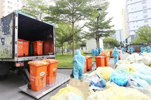 環衛工人在市國立大學宿舍集中隔離區收集醫療廢棄物。（圖源：市黨部新聞網）