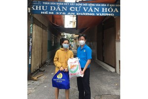 華人幹部文國寶(右)將禮物交給貧困勞動者。