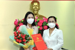 范氏清賢同志（左）從市人民議會主席阮氏麗手中接過委任《決定》和祝賀鮮花。（圖源：越勇）