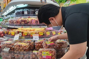 新加坡消費者在超市選購越南荔枝。（圖源：VNA）