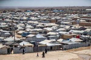 人們在敘利亞東北部哈塞克省，由庫爾德族人管理的阿爾霍爾難民營中穿行，該營地關押著疑似“伊斯蘭國” (IS) 武裝分子的親屬。 （圖源：AFP）