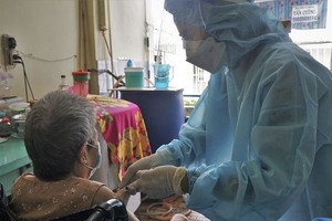 第三郡第五坊武文秦街194號巷行動不便的居民獲得流動疫苗接種 隊的醫護人員上門為其接種新冠疫苗。