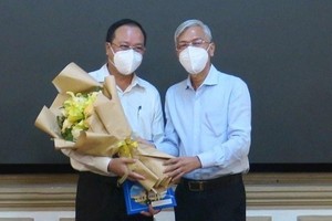 阮玉強同志（左）從市人委會副主席武文歡手中接過委任《決定》和祝賀鮮花。（圖源：廷李）