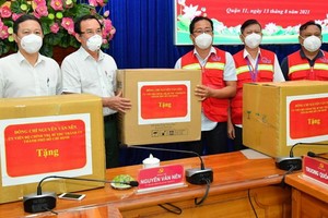 市委書記阮文年（左二）向第十一郡抗疫一線人員贈送禮物。（圖源：紅幸）