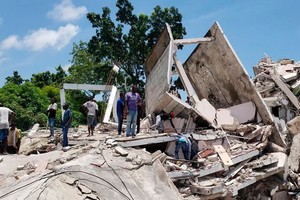 海地Les Cayes，民眾正在清理在地震中倒塌的建築殘骸。（圖源：AP）