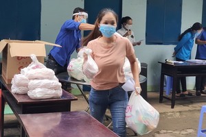 一名貧困勞工領取必需品後趕快回租房去。