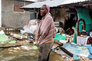 一名年輕人站在一排被海地7.2級地震摧毀的建築外。隨後熱帶低壓格蕾絲又帶來了風暴潮。（圖源：聯合國）