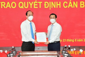 阮黃英同志（右）從市委副書記阮胡海手中接過人事委任《決定》。（圖源：越勇）