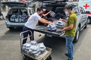 阮維述(左)正在把飯菜搬上車以載到醫院送給病童。