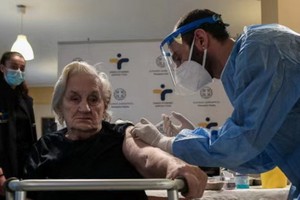 希臘首都雅典的一名大娘接受新冠疫苗注射。（圖源：互聯網）