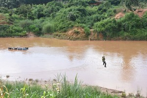 民眾在像筷子頭般細的纜線上蕩著過河。