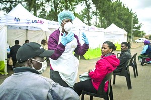 在南非約翰內斯堡，醫護人員給民眾講解檢測程序。（圖源：互聯網）