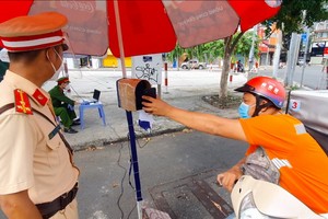 一名快遞員過站時經自動攝像系統掃描健康申報二維碼。（圖源：南范）