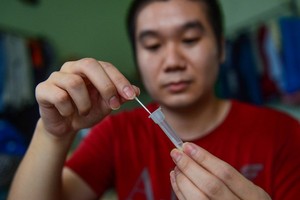 一名男性在家自行做快速檢測。（圖：光定）