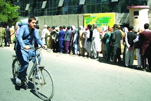 人們在阿富汗喀布爾一家銀行外排隊。（圖源：互聯網）