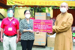 釋慧功法師向第八郡第十三坊黨委副書記馮氏貞轉交救濟品。