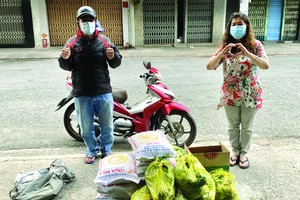 何麗娟(右)把救濟品轉交某單位負責人。