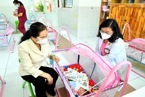 市人民議會主席阮氏麗和雄王醫院經理黃氏艷雪在H.O.P.E中心探望新生兒。