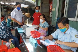 傳統街市人員檢查消費者的購物券。