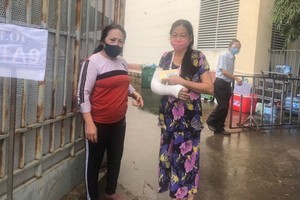 陳氏玉香（左）送一名手骨折的熟人到平盛郡第十三坊接種疫苗。