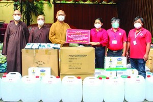 第八郡佛教會執行會長釋慧功法師向郡祖國陣線委員會副主席范氏明月轉交物資。