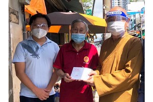 市華人佛教代表釋慧功（右一）與麒麟（左一）向啟秀華文中心校長王沛川贈送慰問金。