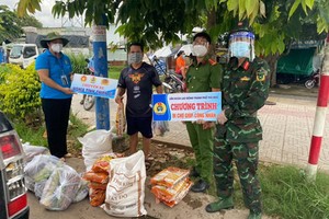 守德市勞動聯團副主席阮氏玉香（左一）向隔離區工人贈送禮物。