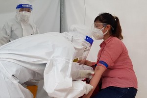 一名女性接受血液取樣以檢測新冠病毒抗體數量。（圖源：何明）