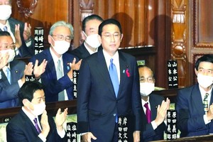 日本國會眾議院舉行的首相指名選舉中，自民黨新總裁岸田文雄（中）起身致謝。（圖源：）