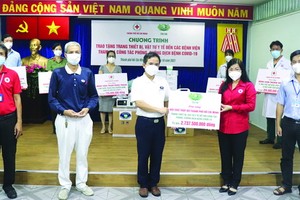 慈濟慈善會越南人醫會黃清俊醫生（中）向鄧氏明孝副主席轉贈醫療裝設備及醫用品。