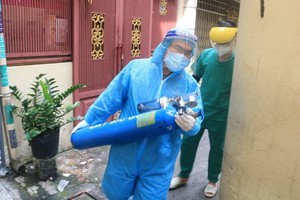 國防部軍醫學院阮維新醫生抱著氧氣瓶，與第六郡第一坊醫療站人員配合急救呼吸困難確診者。