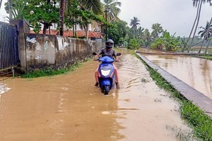 10月16日，在印度南部喀拉拉邦首府提魯沃嫩塔布勒姆，一名男子在積水中騎行。（圖源：新華社） 