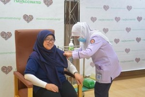 一名汶萊女性接受新冠疫苗注射。（圖源：新華社） 