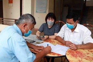 一名市民在簽領紓困金。（圖源: 越通社）