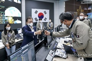 日前，韓總統文在寅（左二）鼓勵航太工作人員碰拳致意。（圖源：韓聯社）