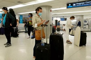 赴美的旅客於 2021年9月20日在佛羅里達州邁阿密機場領取行李。（圖源：AFP）