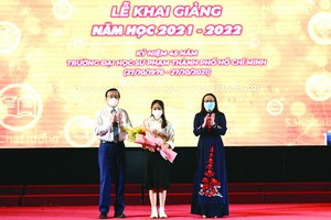 市委宣教處副主任黎鴻山(左)，市師大黨委書記兼董事會主席阮氏明紅(右)向優秀生頒獎。