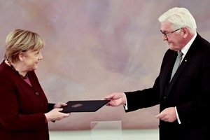 當地時間26日，德國總統施泰因邁爾在默克爾政府卸任儀式上，向默克爾遞交了任期結束通知，默克爾正式卸任總理。（圖源：路透社）