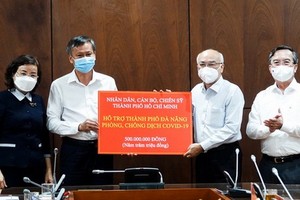 市委宣教處主任潘阮如奎（右二）代表市領導與人民向峴港市捐助5億元、1箱檢測試劑盒與1箱防護服。（圖源：春瓊）